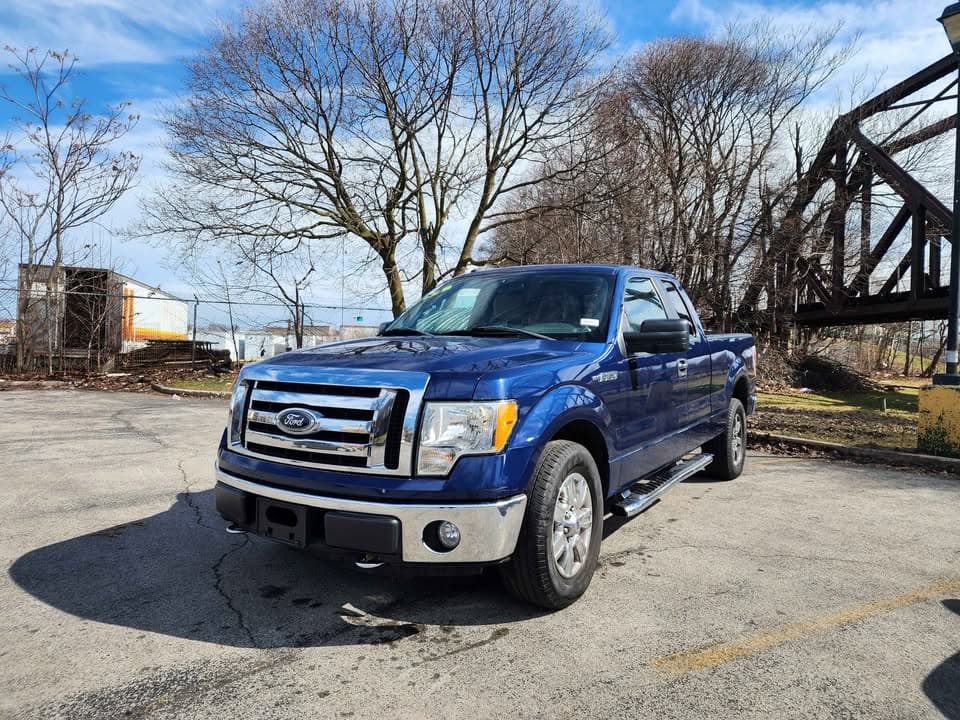 Blue Ford F-150 extended cab pickup with chrome step bars